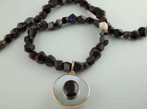 Mother of Pearl holding an oval Garnet on Garnet crystal beads