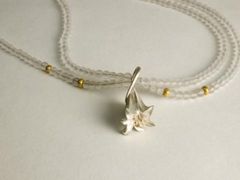Carved silver Lilly on crystal beads with 22ct details
